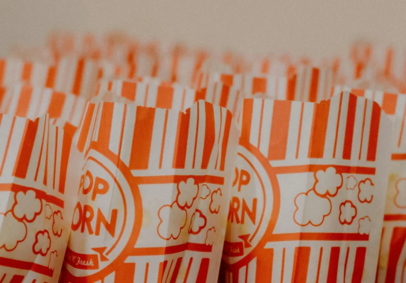 Close-up of popcorn bags with red stripes, ready for movie night or party.