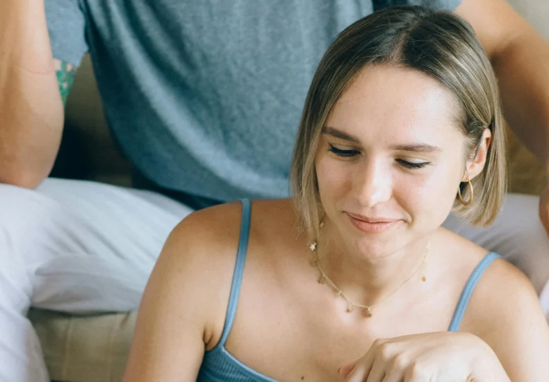 A couple sitting on a sofa browsing a laptop, showcasing online shopping leisure.