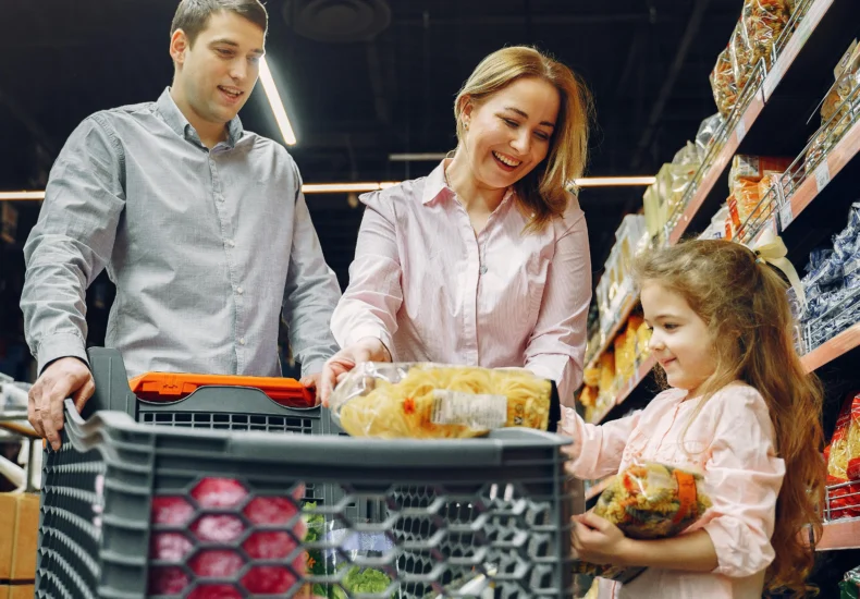 A joyful family of three shopping together in a supermarket, creating a memorable experience.