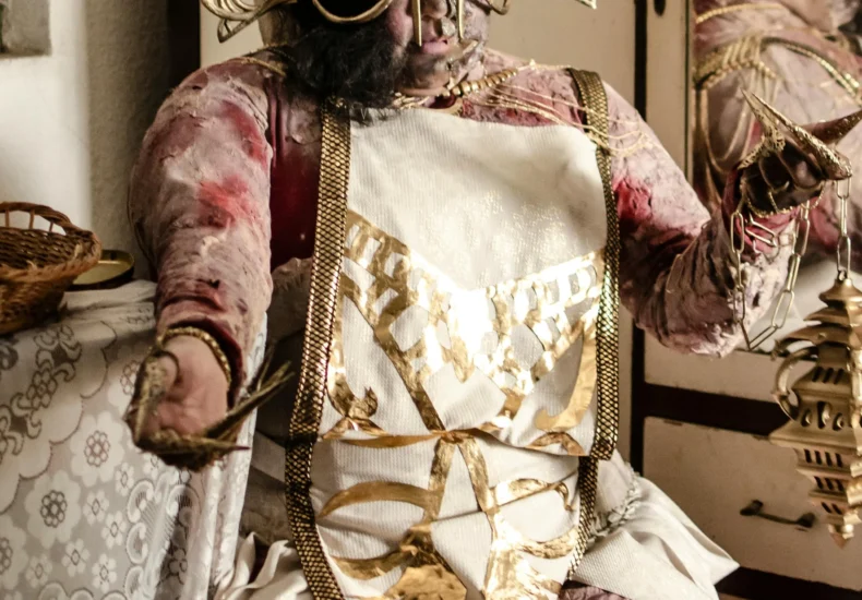 Intricate horror costume with metallic mask and fabric details in an indoor setting.