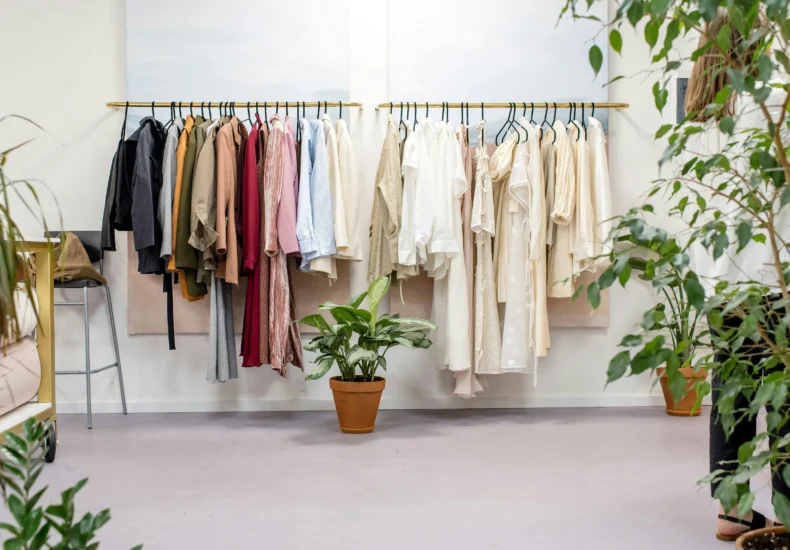 Chic fashion boutique showcasing vibrant clothing collection with lush indoor plants.