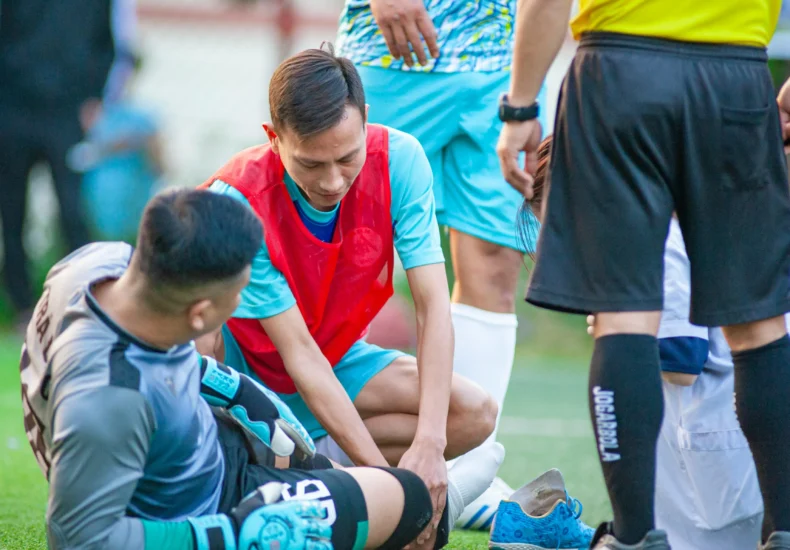 A soccer player receives assistance after an injury during a match in Hanoi, Vietnam.