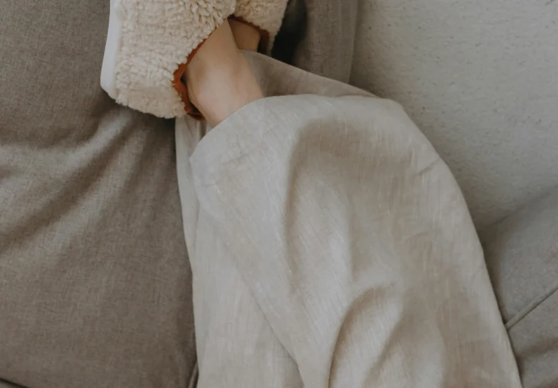 Relaxed person lounging indoors with plush slippers, conveying warmth and comfort.